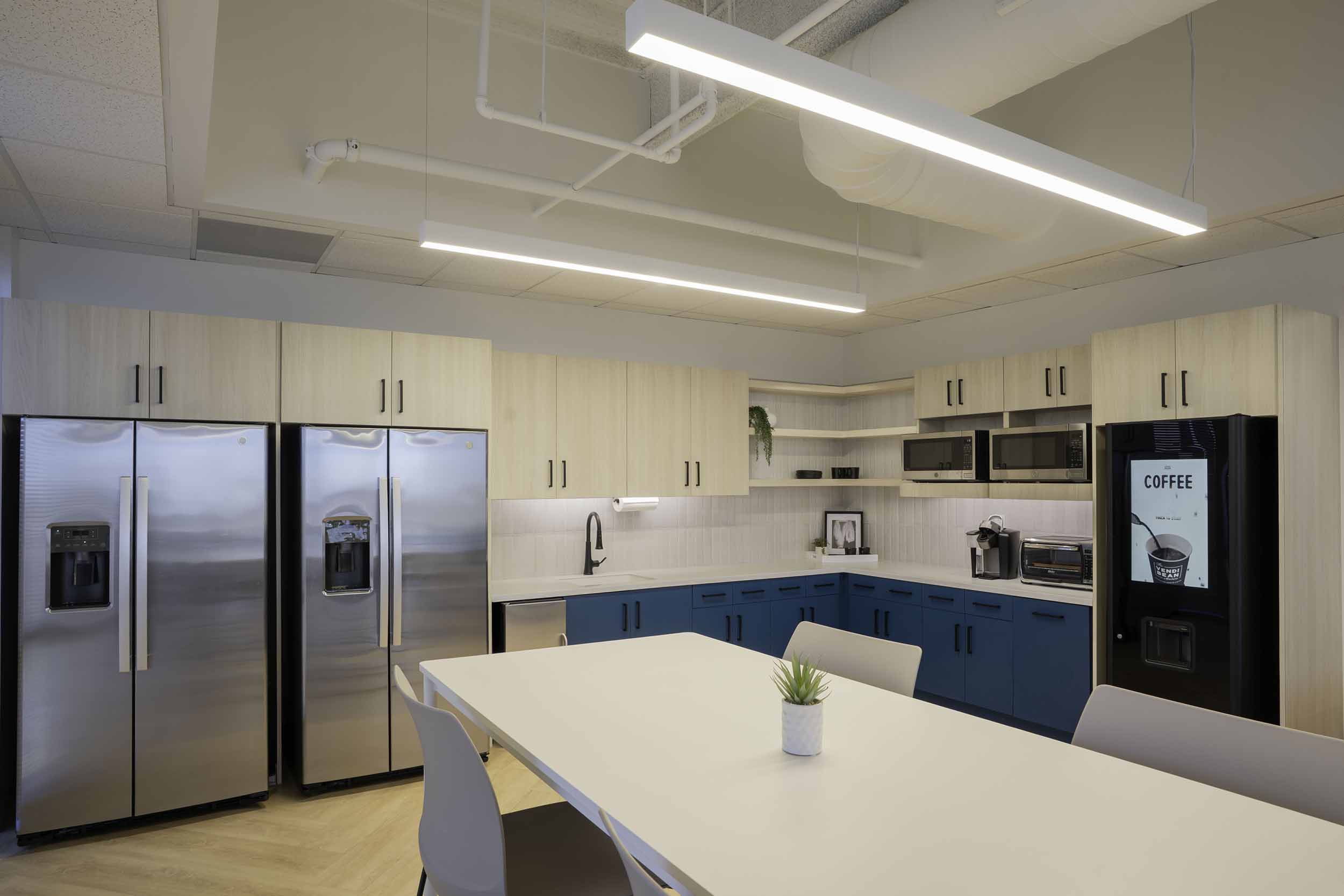 Breakroom kitchen with coffee dispenser in room designed by Planning Interiors